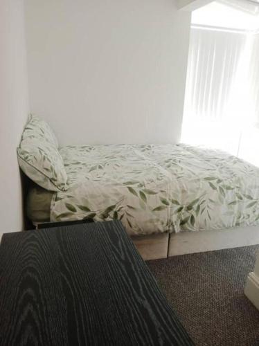 1 cama no hecha en un dormitorio con ventana en Double bed (R2) close to Burnley city centre, en Burnley