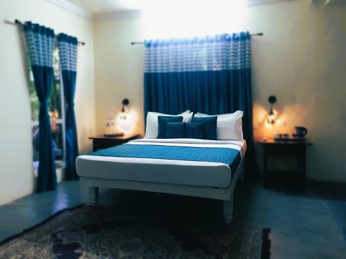 a bedroom with a bed with blue and white pillows at Marari Dreamz Homestay in Mararikulam
