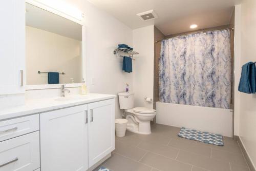 bagno con servizi igienici, lavandino e specchio di Comfy Apt with pool & hot tub in downtown LA' a Los Angeles
