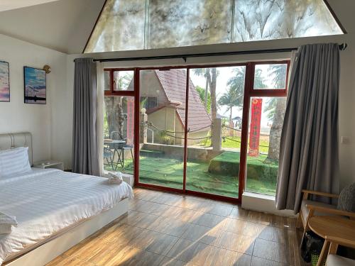 a bedroom with a bed and a large window at Koh RhongSunshine Resort in Phumĭ Kaôh Rŏng