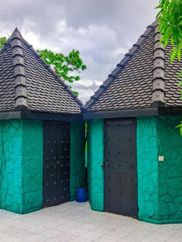 two buildings with green and black doors at Châteaux Yolande in Mahajanga