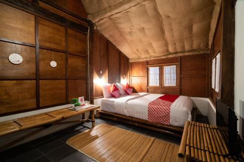 1 dormitorio con 1 cama y un banco en una habitación en OYO 2393 Putroyono Homestay en Magelang