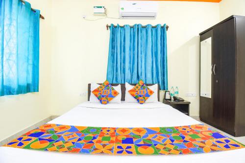 FabExpress Shanel Beachside Resort في باغا: غرفة نوم مع سرير مع لحاف جميل