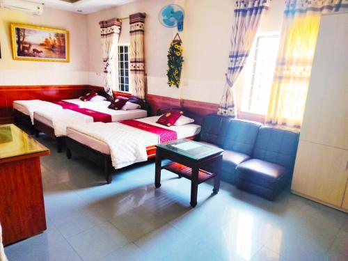 salon z 2 łóżkami i kanapą w obiekcie GRAD Hoa Do Hotel w mieście Xuân Ðài