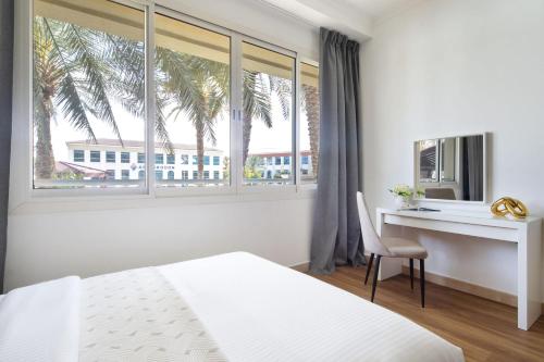 a bedroom with a bed and a desk and a window at Frank Porter - Lake Apartment in Dubai