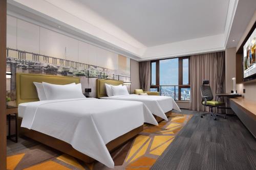 a hotel room with two beds and a desk at Hampton by Hilton Guangzhou Luoxi in Guangzhou