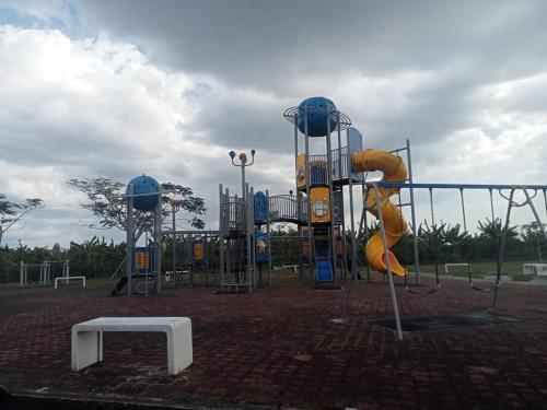 a playground with a slide and a play structure at MR OT HOMESTAY ( BAITUL RAUDHAH ) in Kepala Batas