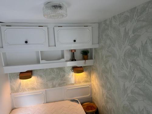 a room with two white cabinets and a table at Stacaravan 130 De Tien Heugten in Schoonloo