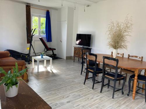- un salon avec une table et des chaises en bois dans l'établissement Maison 5 personnes, au Mans