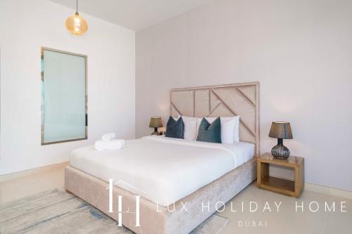 ein Schlafzimmer mit einem großen weißen Bett und einem Spiegel in der Unterkunft LUX - Opulent Island Suite 3 in Dubai