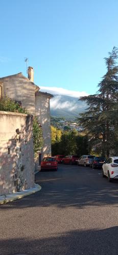 un estacionamiento con autos estacionados frente a una montaña en Studio tout confort en Provence Mont Ventoux., en Bédoin