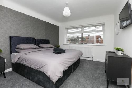 a bedroom with a large bed and a television at Newly Renovated 3 Bedroom House with Parking by Amazing Spaces Relocations Ltd in Liverpool