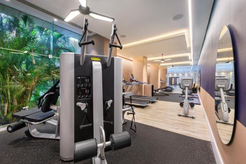 un gimnasio con cintas de correr y equipos de ejercicio y un mural de palmeras en Nevo by Isrotel Collection, en Ein Bokek