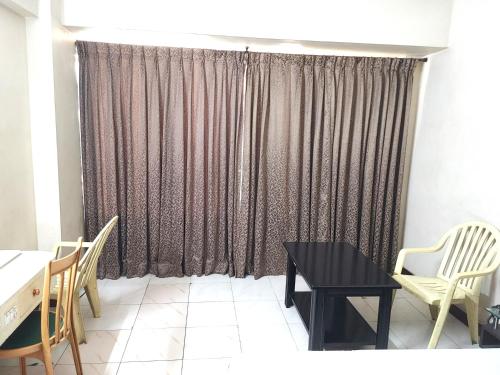 a room with a table and chairs and a curtain at Hotel Diana Gandhipuram in Coimbatore