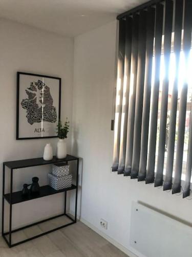 a room with a window and a shelf with vases at Hus sentralt på sentrum in Alta