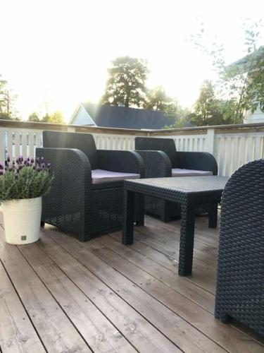 eine Terrasse mit Korbstühlen und Tischen auf einer Terrasse in der Unterkunft Hus sentralt på sentrum in Alta