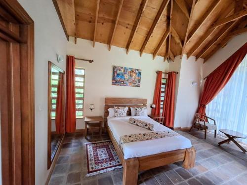 a bedroom with a bed in a room with wooden ceilings at Od Kidi Cottages in Migori