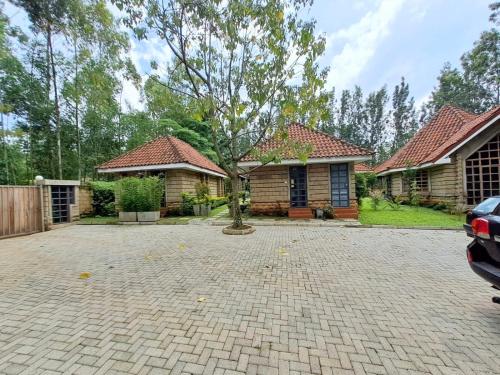 a house with a tree in the middle of a driveway at Od Kidi Cottages in Migori