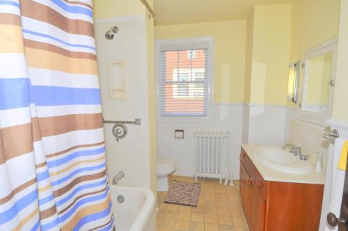 a bathroom with a tub and a toilet and a sink at Aunt Bea's Bungalow - Pet Friendly - Hot Tub - Screen Porch - Wifi - Fenced Yard - King Bed - Town in Berkeley Springs