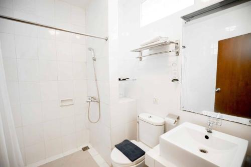 Baño blanco con aseo y lavamanos en Cakra Kembang Hotel, en Yogyakarta