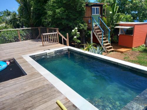 a swimming pool with a deck and a house at Villa vue exceptionnelle in Saint-Leu