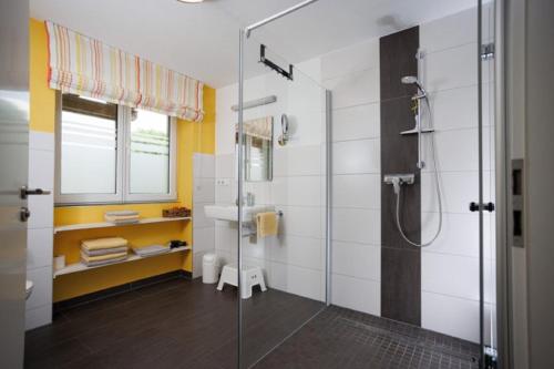 y baño con ducha acristalada y lavamanos. en KrämersBug - Unterkunft für Familien mit kleinen Kindern, en Simmershofen