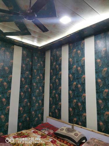 マトゥラーにあるKadiya dharamshalaのベッドルーム(シーリングファン、ベッド付)
