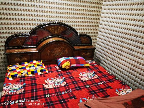 ein Bett mit einer Decke und Kissen darauf in der Unterkunft Kadiya dharamshala in Mathura