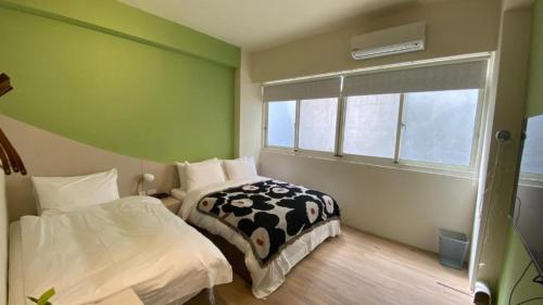 a bedroom with two beds and a window at 日月慢遊 in Yuchi
