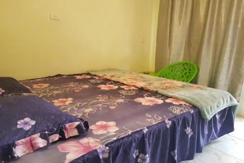 een bed in een kamer met een sprei met bloemen erop bij OYO 93771 Sejolie Sibayak in Berastagi