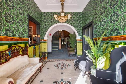 a living room with green walls and a chandelier at Victoria and Albert Guesthouse in Mount Victoria