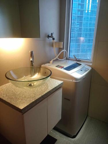 a bathroom with a glass bowl sink and a window at 2 Bedrooms Units Forbes Area 5th Avenue BGC Center in Manila