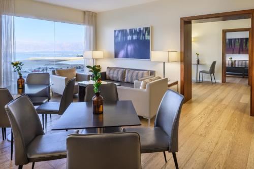 a living room with tables and chairs and a couch at Nevo by Isrotel Collection in Ein Bokek