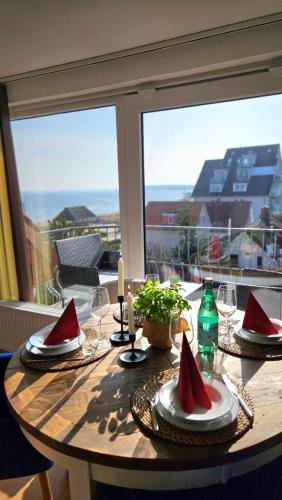 a wooden table with red napkins on top of it at ٤Neu٤Fantastischer Meerblick-Stylish-King Bed-PP in Scharbeutz