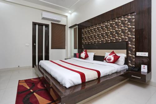 a bedroom with a large bed with red pillows at OYO KN Plaza in Sikandra