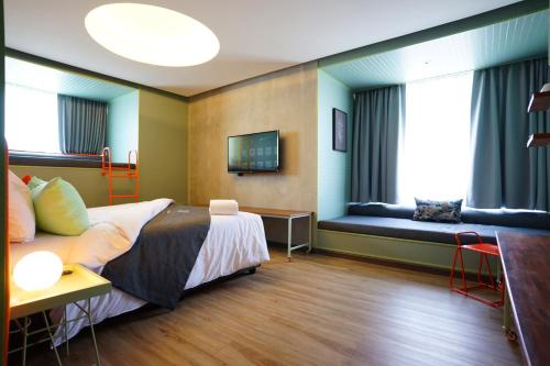 a hotel room with a bed and a couch at Samsen Street Hotel in Bangkok