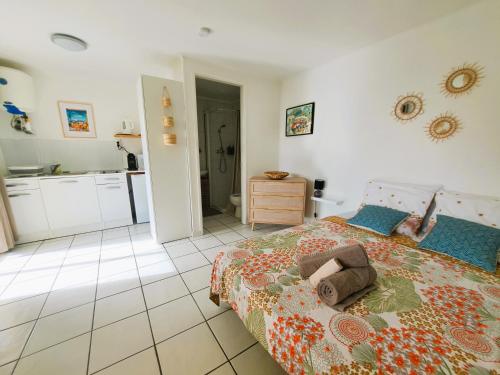 a bedroom with a bed and a kitchen at Bungalow Jazz - Bassin Manapany-Les-Bains in Saint-Joseph