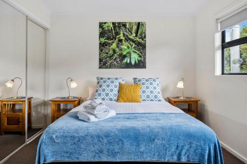 a bedroom with a blue bed with two lamps at Cottage on Chapman in Dover