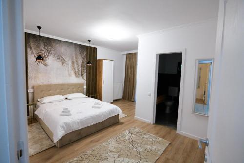a bedroom with a bed and a painting on the wall at Flori de Tei Maramures in Săcel
