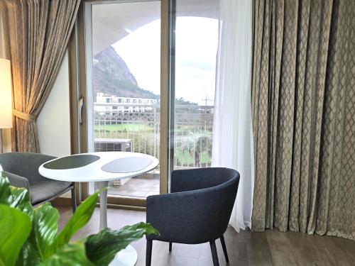a room with a table and chairs and a large window at MJ Pension & Resort in Seogwipo