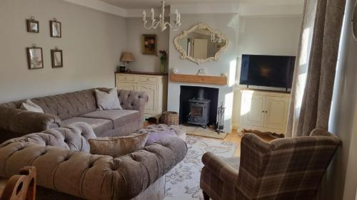 ein Wohnzimmer mit Couch und Kamin in der Unterkunft Wren Cottage in Heacham