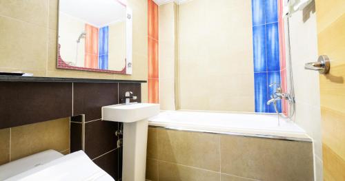 a bathroom with a sink and a toilet and a mirror at Sacheon Tourist Hotel in Sacheon