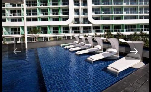 a row of chairs in a pool in front of a building at AZURE HOTEL RESORT Ph15 St Tropez in Manila