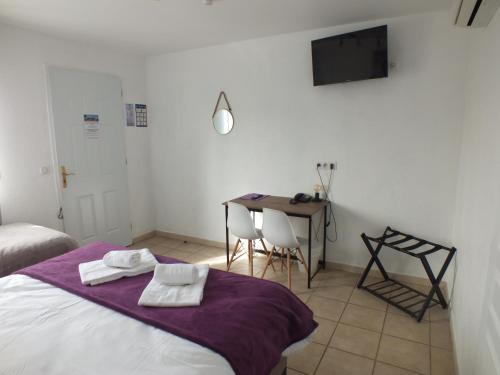 sypialnia z łóżkiem, stołem i telewizorem w obiekcie Logis hôtel restaurant Le clos saint loup w mieście Bram