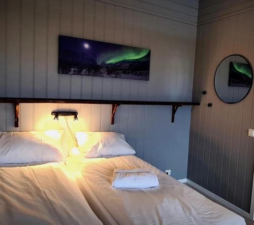 a bedroom with two beds and a tv on the wall at Marmelkroken AS in Bø Andøya