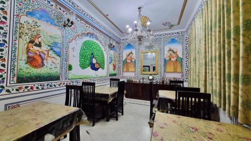 a restaurant with colorful walls with tables and chairs at The Kunadi Heritage by Boho Stays in Jaipur