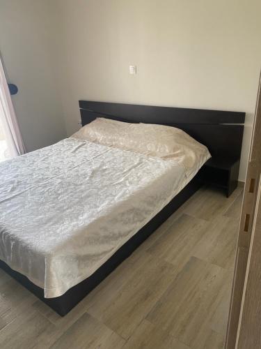 a bed in a bedroom with a wooden floor at Anastasia Apartment in Kalivia Poligirou