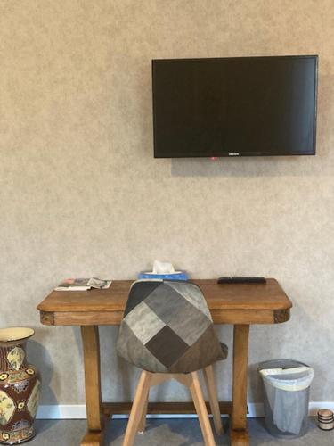 a wooden table with a television on a wall at Coup de cœur en Brenne in Martizay