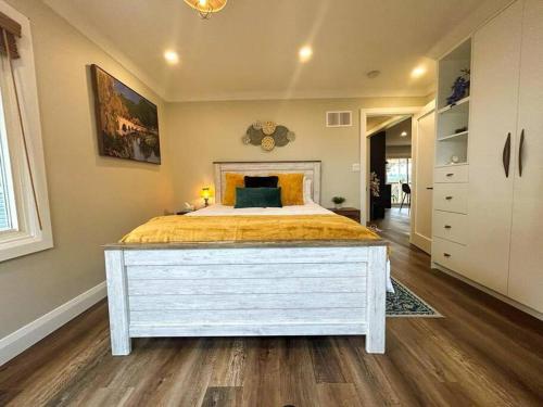 1 dormitorio con 1 cama grande con colcha amarilla en Elite Upper Deck Suites l Lake front with hot tub, en Cayuga