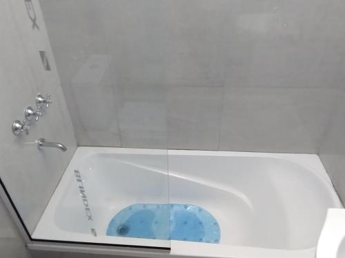 La salle de bains est pourvue de toilettes blanches avec un siège bleu. dans l'établissement DEPARTAMENTO - Excelente ubicación y Comodidad 3B, à San Nicolás de los Arroyos